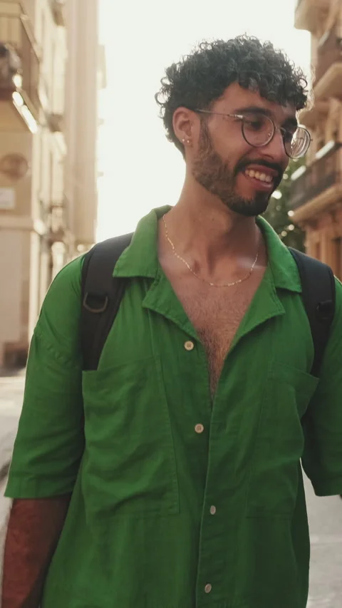 Brunette guy tourist with beard, dressed in green shirt, walks around city Stock Footage 255505149