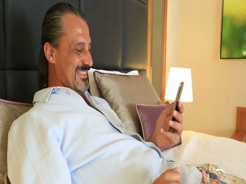 Brunette handsome man talking via internet with smartphone Video stock 73619793