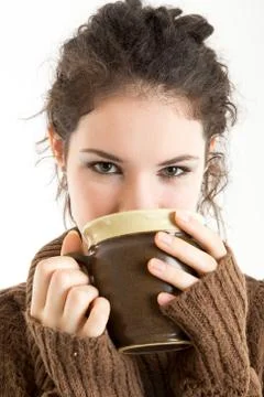 Brunette in knitted pullver drinking from a mug Stock Photos