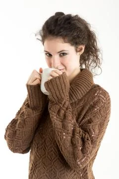 Brunette in knitted pullver drinking from a mug Stock Photos