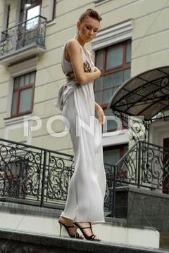 Brunette in long dress near a hotel Stock Photos