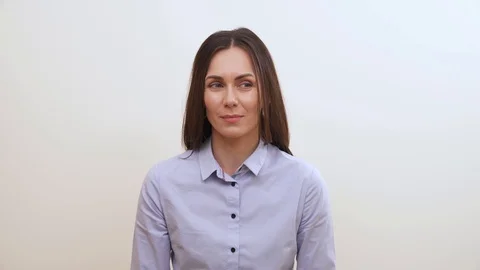 A brunette is looking to the right, in front of her, moves her head, smiles. Stock Footage 100059155