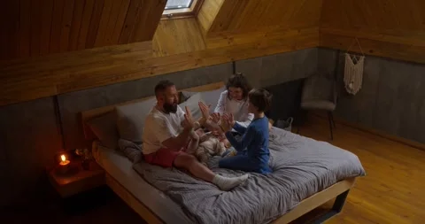 A brunette man with a beard plays a game with his son with the help of his palms Vídeos de archivo 313353529