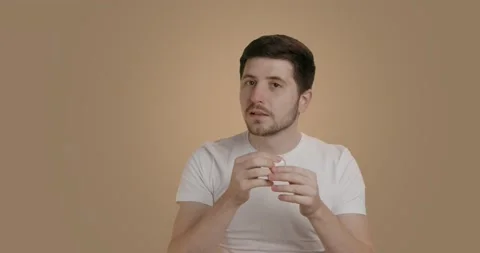 A brunette man dressed in a basic white tank top does his routine in the Video stock 231258316