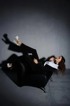 Brunette model posing on couch in the studio Stock Photos