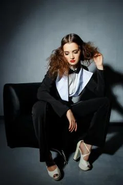 Brunette model posing on couch in the studio Stock Photos