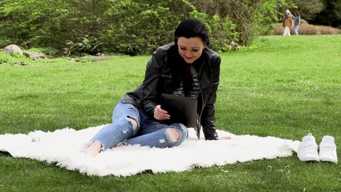Brunette in nature with a tablet 库存影片 106999944