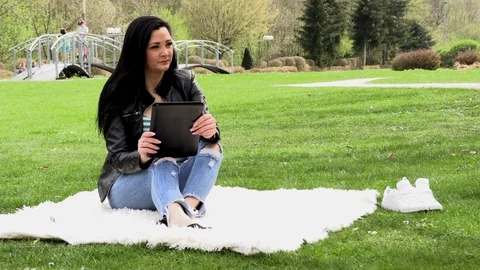 Brunette in nature with a tablet Stockbeeldmateriaal 107000326
