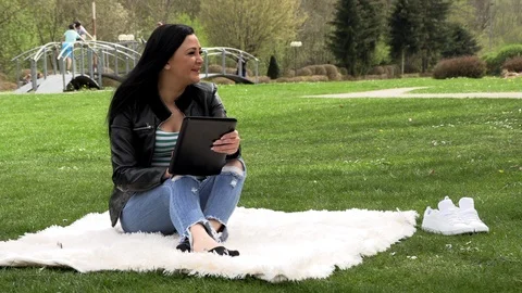 Brunette in nature with a tablet Stock Footage 107034906