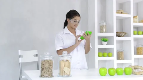 Brunette nutrition technician receiving message on mobile phone while working Stockbeeldmateriaal 199629307