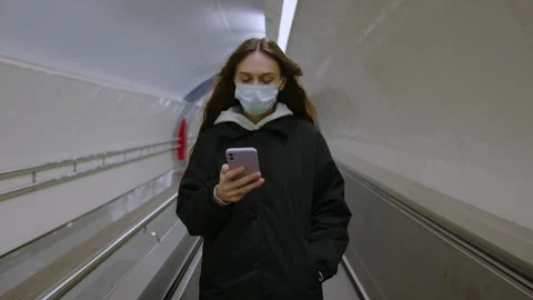 Brunette online in mobile phone while riding an escalator.Modern city transport Stock Footage 248442596
