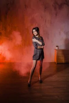 Brunette posing in a cloud of orange smoke Stock Photos