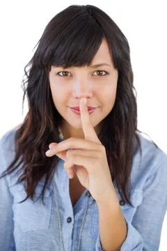 Brunette putting finger on her mouth for silence Stock Photos