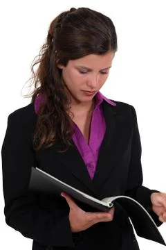 Brunette reading contents of folder Stock Photos