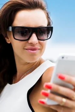 Brunette with red fingernails using her phone Stock Photos