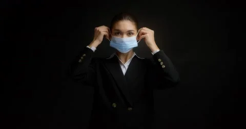 Brunette shows how to properly put on a medical mask and gives a thumbs up Stock Footage 172101466