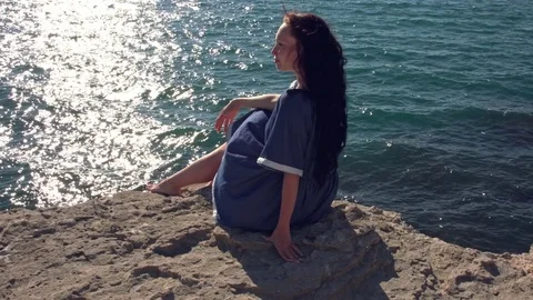 Brunette sits on the edge of the world Stock Footage 79424437