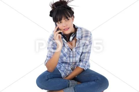 Brunette sitting on the floor with headphones calling someone Stock Photos