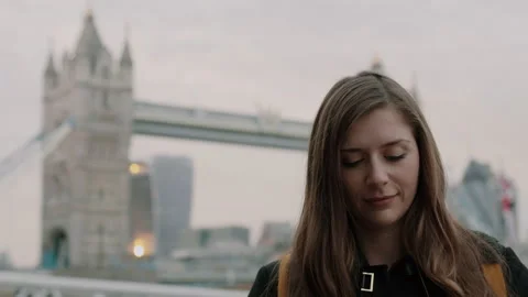 Brunette Smiling and Looking down with Tower Bridge in the Background Video stock 131486296
