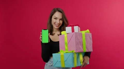 Brunette stands on a red background and holds gifts for Christmas, chromakey Stock Footage 249798708