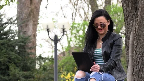 Brunette on a street bench with a tablet Stock-Footage 106897853