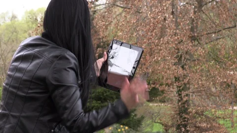 Brunette on a street bench with a tablet 库存影片 106916348