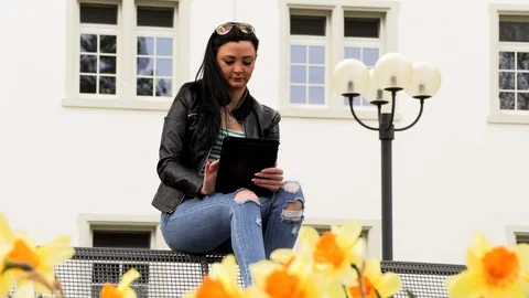 Brunette on a street bench with a tablet Stock Footage 106951787