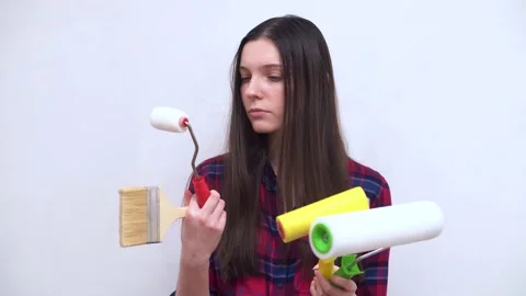 Brunette thinks how to paint a wall Stock Footage 201609286