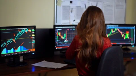 Brunette trader female checking computer monitors full of financial trade tables Stockbeeldmateriaal 93859244
