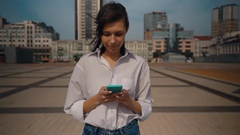 Brunette typing message outdoors Stock Footage 125959916