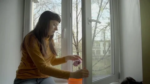 The brunette washes the window on a spring day. Stock Footage 75178862