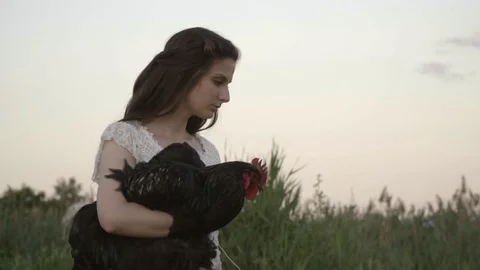Brunette In The White Lace Dress Holds The Big Rooster Stock Footage