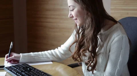 Brunette in white sweater working at a computer Stock-Footage 47180298