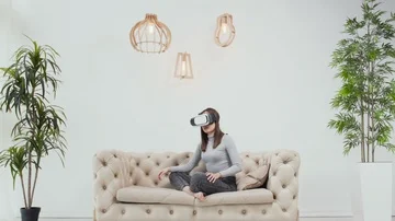 Brunette women using  Virtual Reality glasses. VR in white minimalistic room. Stock Footage 85527587