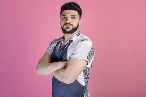 Brunette worker, handyman with beard posing indoors, standing with crossed hands 스톡 사진