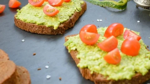 Bruschetta with avocado, cherry tomatoes and spices Stock Footage 72587124