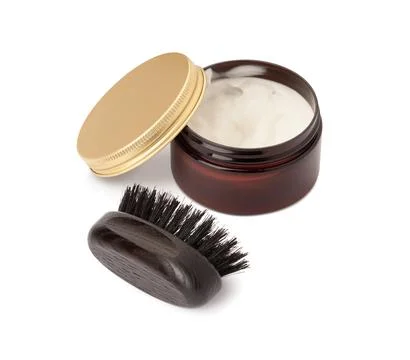 A brush and open jar with a gold lid, a beard and hair care product Stock Photos