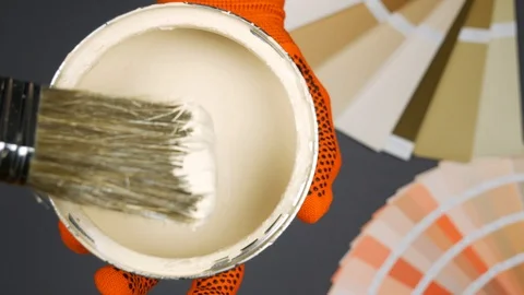 A brush and opened can with beige paint over gray background. Palette Video stock 101808200