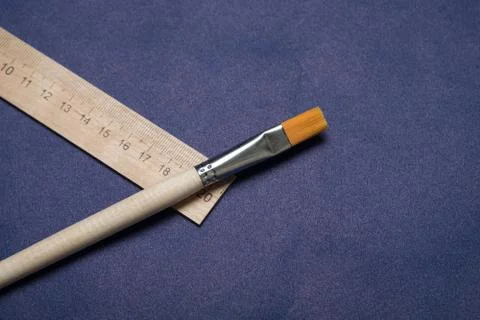 Brush and ruler studio image. School ruler with a brush for painting on a blu Stock Photos