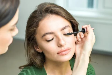 Brush applying beige makeup Stock Photos