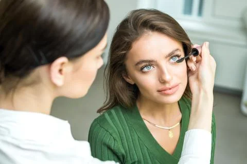 Brush applying beige makeup Stock Photos