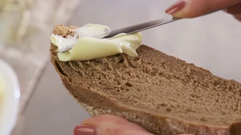 Brush the bread with organic butter. Spread soft butter on a piece of bread Stock Footage 153158546