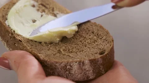 Brush the bread with organic butter. Spread soft butter on a piece of bread Stock Footage 156239302