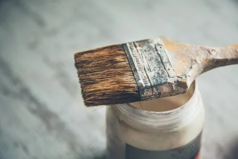 Brush on can with paint on table Stock Photos