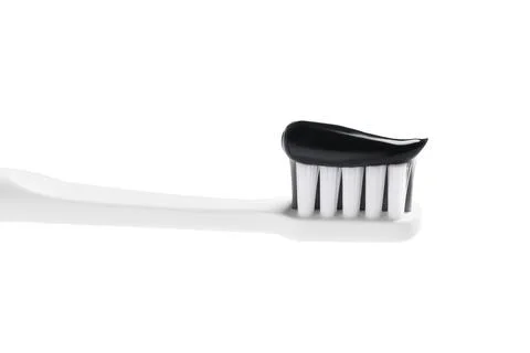 Brush with charcoal toothpaste isolated on white Stock Photos