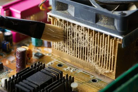 Brush cleaning an old computer board from dust and dirt. Close-up. Stock Photos