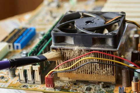Brush cleaning an old computer board from dust and dirt. Close-up. Stock Photos