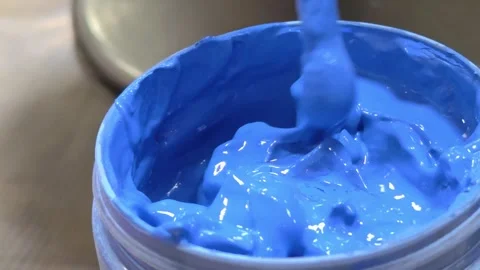 Brush dipped in a jar with blue paint close-up. Dip brush into the paint. Stock Footage 304630845