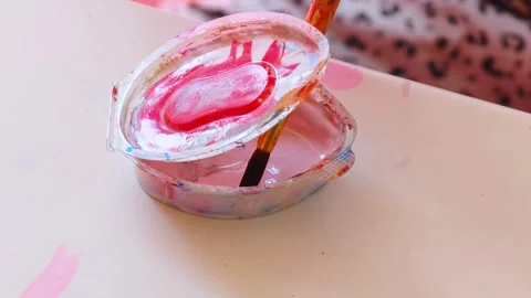 Brush dipped in a jar with pink paint close-up. Dip brush into the paint. Stock Footage 317019529