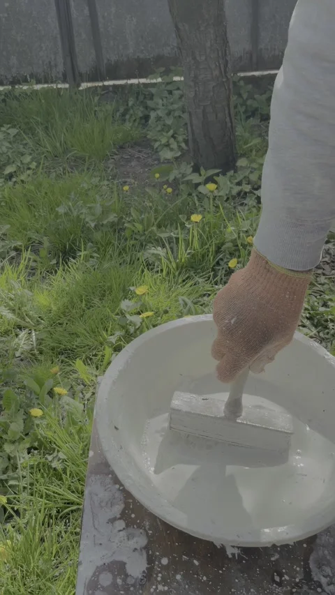 Brush dipping into bucket of whitewash solution Stock Footage 334330459